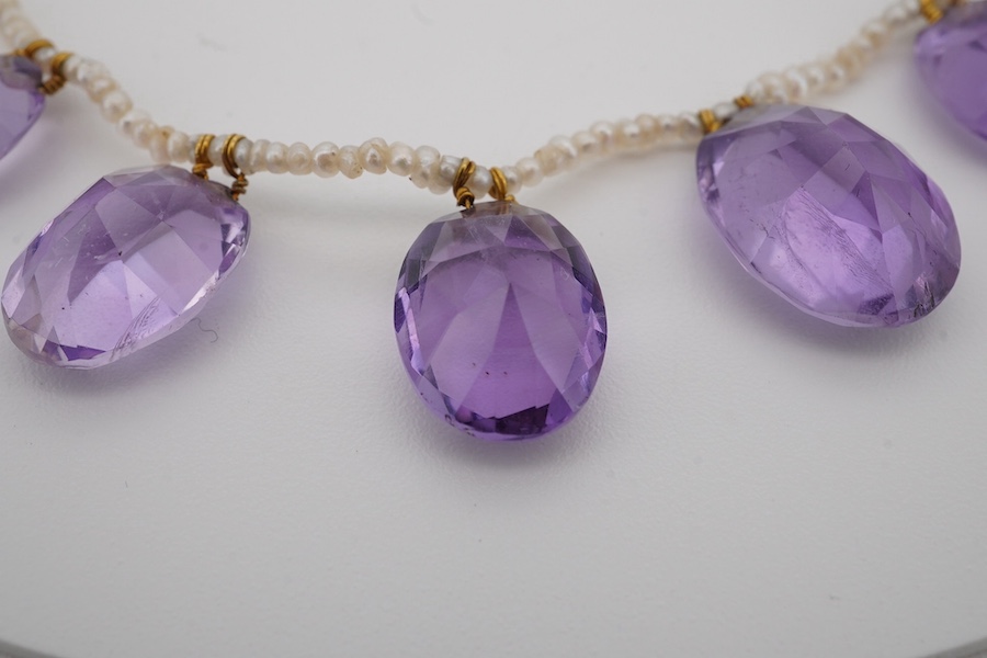 An early 20th century seed pearl and graduated oval cut amethyst set fringe necklace, 36cm. Condition - fair to good